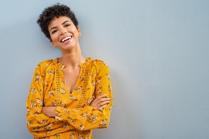 Happy woman smiling against wall